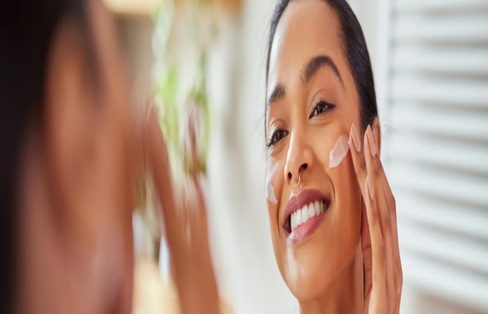 Person applying skincare cream to improve skin tone and reduce dark spots